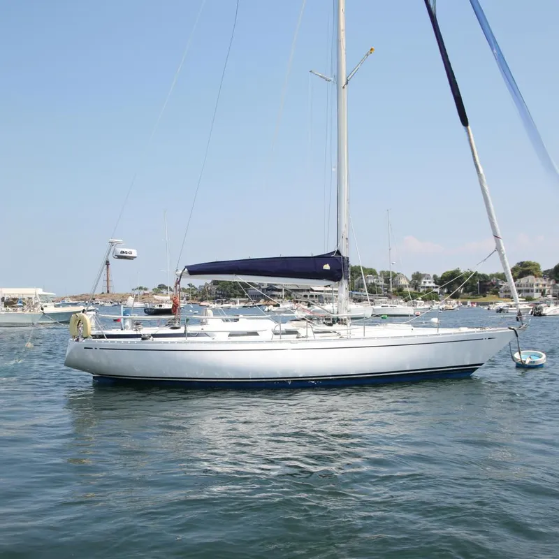 The Image of 1974 Nautor Swan 38 sailboat anchored in a scenic harbor. - 0