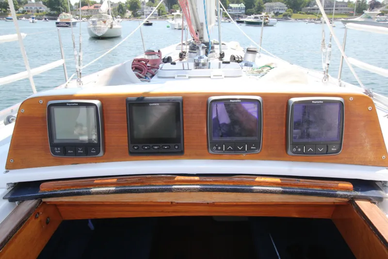Slide: The Image of Cockpit of 1974 Nautor Swan 38 sailboat with navigation instruments, docked in a scenic harbor. - 16