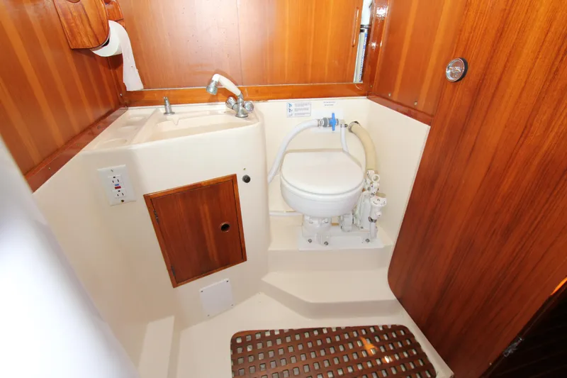 Slide: The Image of 1974 Nautor Swan 38 yacht bathroom with wooden paneling and compact fixtures. - 19
