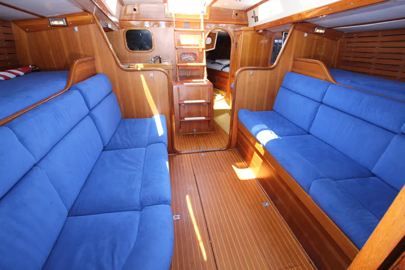 Slide: The Image of Interior of 1974 Nautor Swan 38 yacht with blue cushioned seating and wooden finishes. - 20