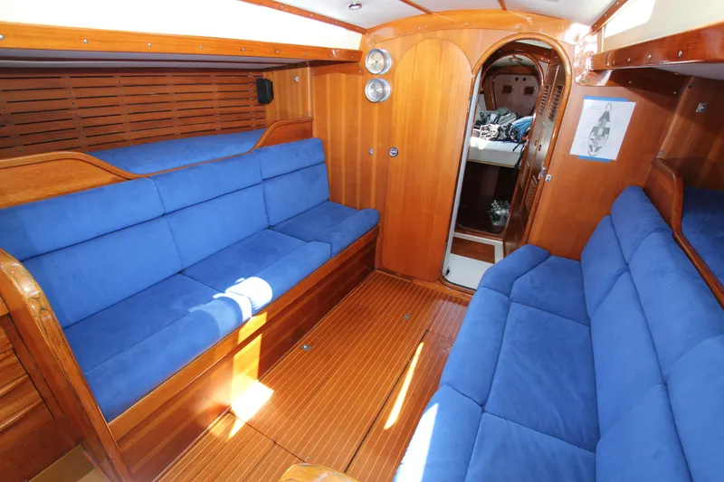 Slide: The Image of Interior of 1974 Nautor Swan 38 yacht with blue cushioned seating and wooden finishes. - 21