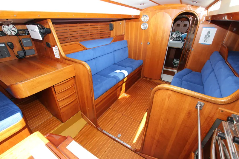 Slide: The Image of Interior of a 1974 Nautor Swan 38 yacht with wooden finish and blue seating. - 23