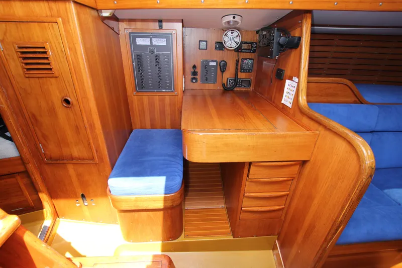 Slide: The Image of 1974 Nautor Swan 38 yacht interior with wooden navigation station and blue cushioned seating. - 25