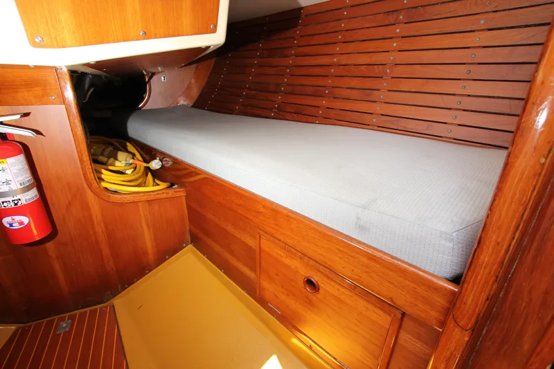 Slide: The Image of Interior of 1974 Nautor Swan 38 sailboat with wooden paneling and cushioned berth. - 29