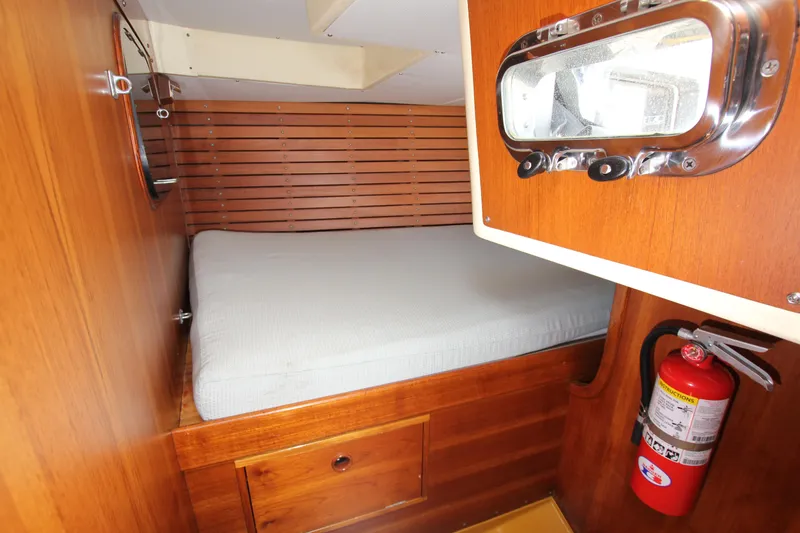 Slide: The Image of Cozy cabin interior of 1974 Nautor Swan 38 sailboat with wooden finish and fire extinguisher. - 30