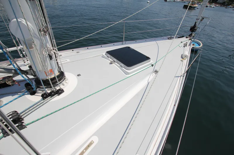 Slide: The Image of Deck of 1974 Nautor Swan 38 sailboat with mast and hatch, on calm water. - 4