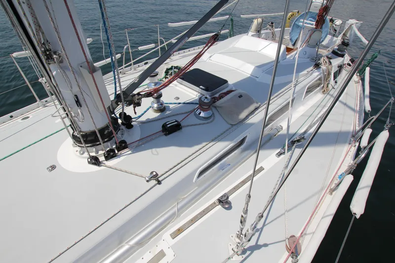 Slide: The Image of 1974 Nautor Swan 38 sailboat deck with rigging and winches, on calm water. - 6