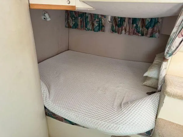 Slide: The Image of 1995 Cruisers Yachts 3175 Rogue cabin with cozy bed and patterned curtains. - 14
