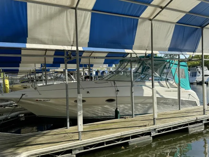 Slide: The Image of 1995 Cruisers Yachts 3175 Rogue docked under a blue and white canopy. - 2
