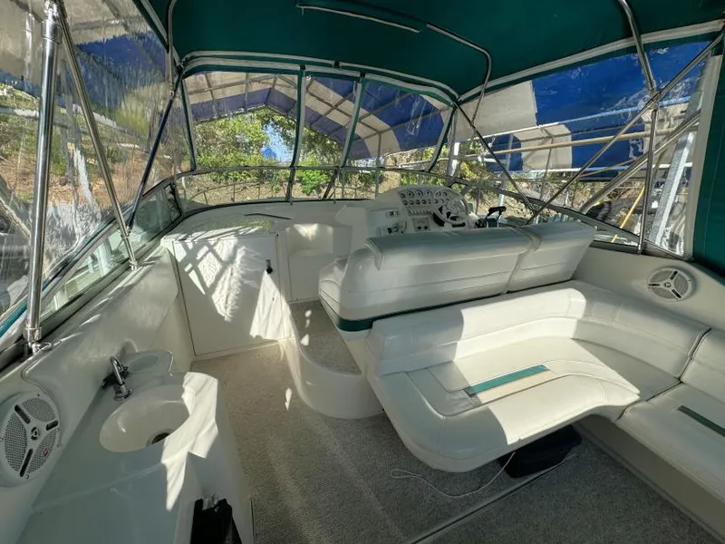 Slide: The Image of 1995 Cruisers Yachts 3175 Rogue interior with seating and helm under green canopy. - 3