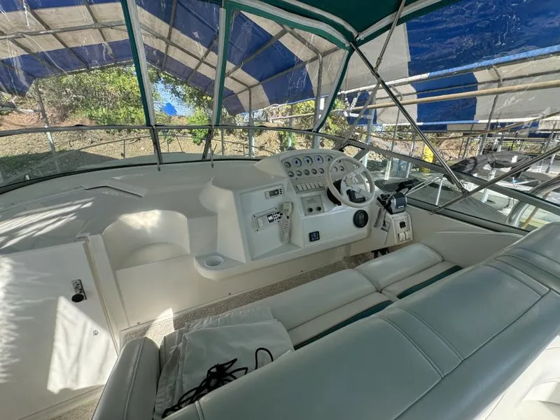 Slide: The Image of 1995 Cruisers Yachts 3175 Rogue cockpit with steering wheel and seating under canopy. - 8