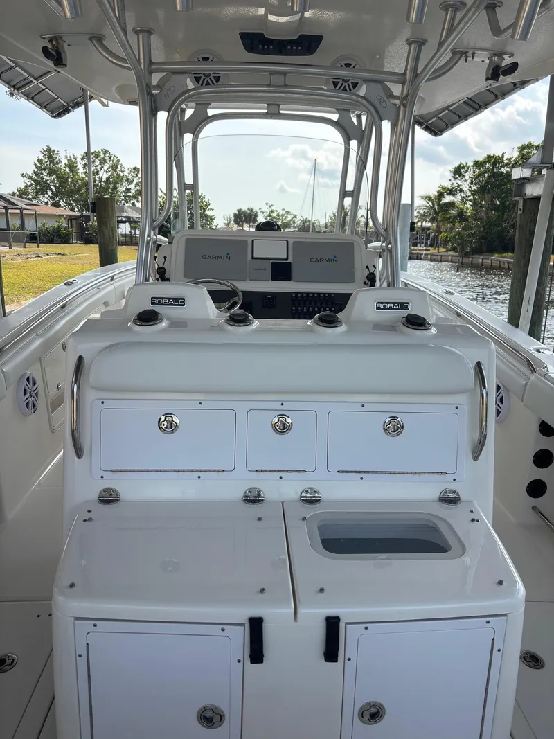 Slide: The Image of 2015 Robalo R300 Center Console boat interior with storage compartments and control panel. - 12