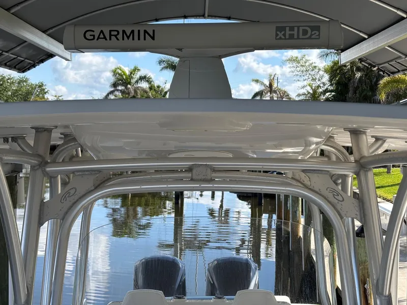 Slide: The Image of 2015 Robalo R300 Center Console with Garmin xHD2 radar, docked by a serene waterway. - 23