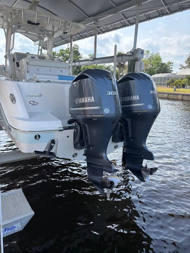 Slide: The Image of 2015 Robalo R300 Center Console with twin Yamaha 300 engines docked by the water. - 3