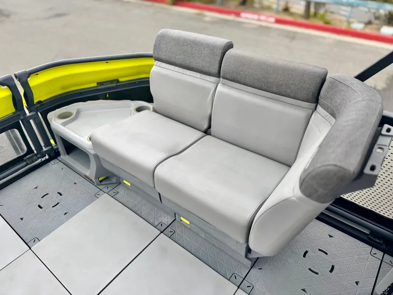 Slide: The Image of 2023 Sea-Doo Switch Cruise 18 interior seating with gray upholstery and cup holders. - 12