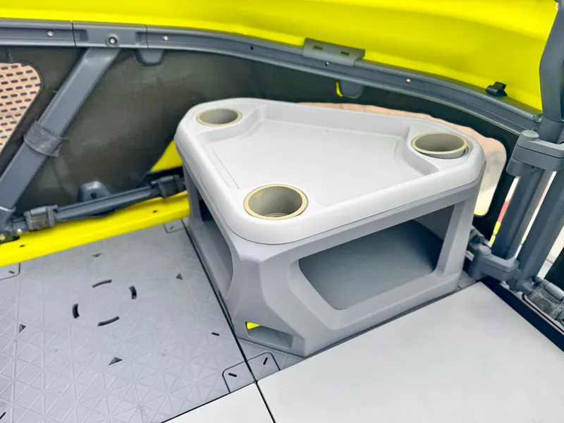 Slide: The Image of 2023 Sea-Doo Switch Cruise 18 interior with a triangular table and cup holders. - 13