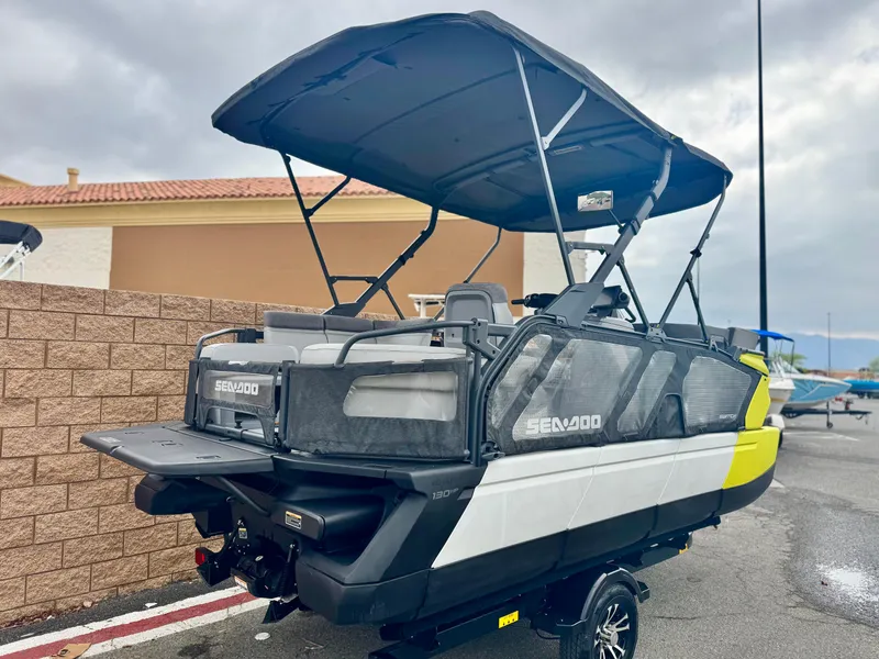 Slide: The Image of 2023 Sea-Doo Switch Cruise 18 pontoon boat with canopy, parked outdoors on a trailer. - 6