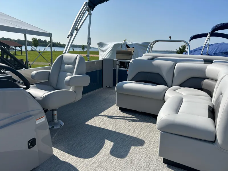 Slide: The Image of 2023 Landau Island Breeze 232 Cruise pontoon boat interior with plush seating and helm. - 9