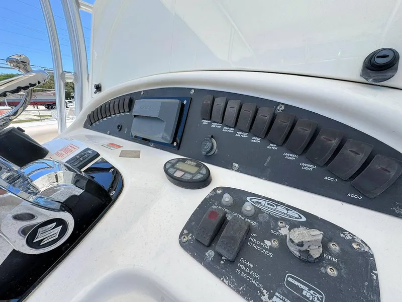Slide: The Image of Control panel of a 2004 Boston Whaler 320 Outrage boat, featuring various switches and gauges. - 10