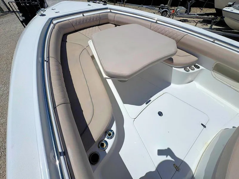 Slide: The Image of 2004 Boston Whaler 320 Outrage boat interior with beige seating and table. - 14