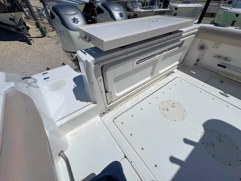 Slide: The Image of 2004 Boston Whaler 320 Outrage boat deck with storage compartments and dual engines. - 5