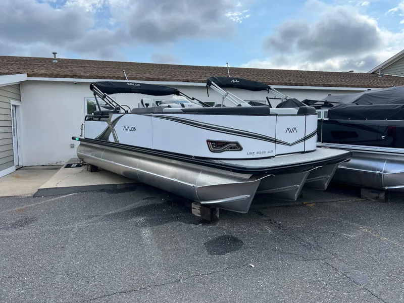Slide: The Image of 2025 Avalon 2385 LSZ pontoon boat parked outdoors under cloudy sky. - 0