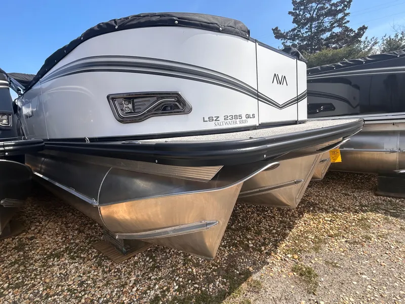 Slide: The Image of 2025 Avalon 2385 LSZ pontoon boat on gravel, showcasing sleek design and sturdy pontoons. - 10