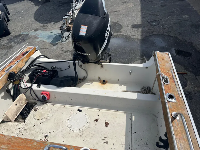 Slide: The Image of 1992 Boston Whaler 19 Outrage boat interior with Suzuki outboard motor, showing deck and controls. - 9