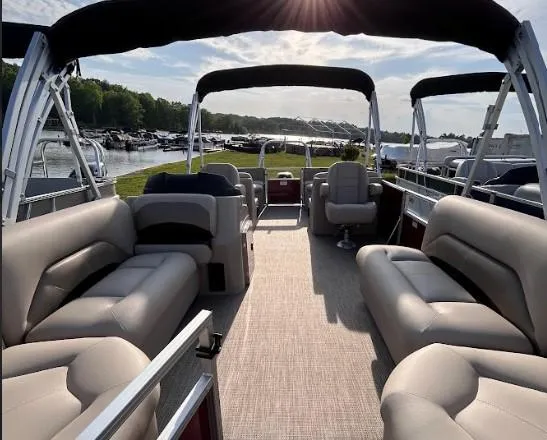 Slide: The Image of 2024 Landau Island Breeze 232 Cruise pontoon boat with spacious seating and canopy, docked by a lake. - 5