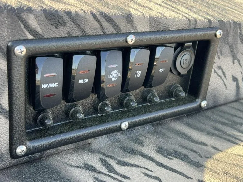 Slide: The Image of Control panel of 2025 Havoc Boats 1653 MSTC with labeled switches and 12V outlet. - 13