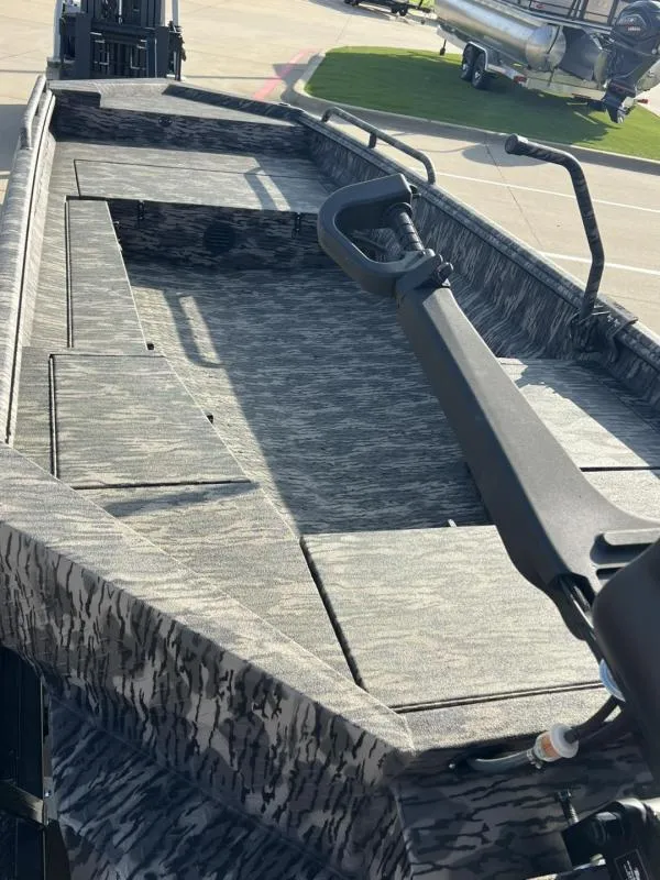 Slide: The Image of 2025 Havoc Boats 1653 MSTC with camouflage interior, parked outdoors. - 16