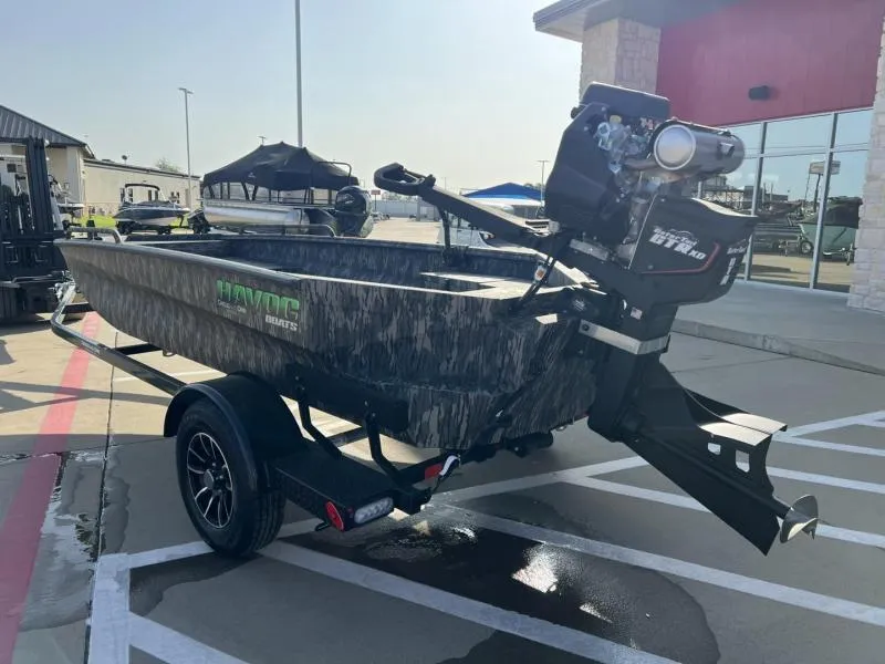 Slide: The Image of 2025 Havoc Boats 1653 MSTC on trailer, parked outdoors, showcasing camo design and powerful motor. - 3
