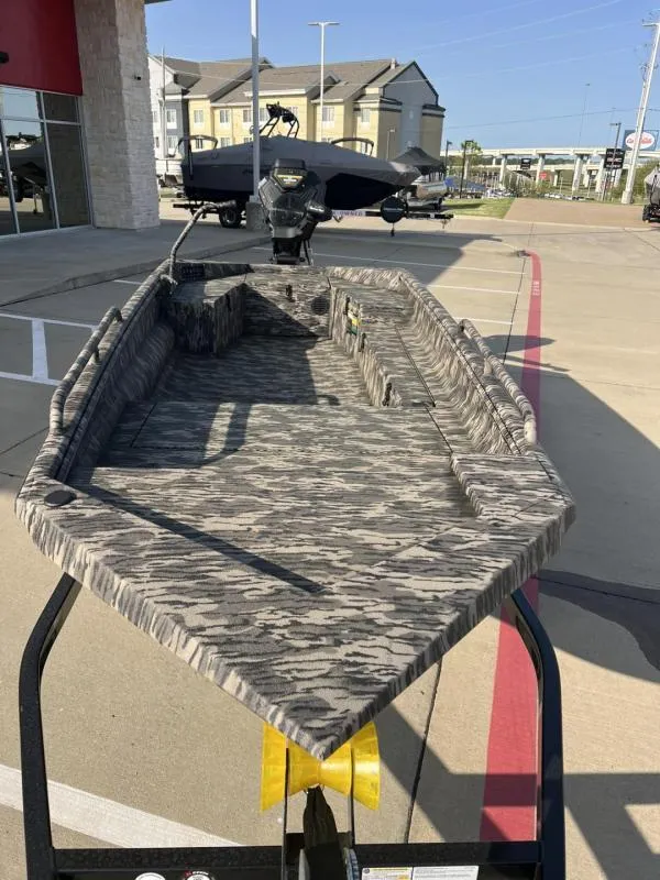 Slide: The Image of 2025 Havoc Boats 1653 MSTC with camouflage interior, parked outdoors on a sunny day. - 8