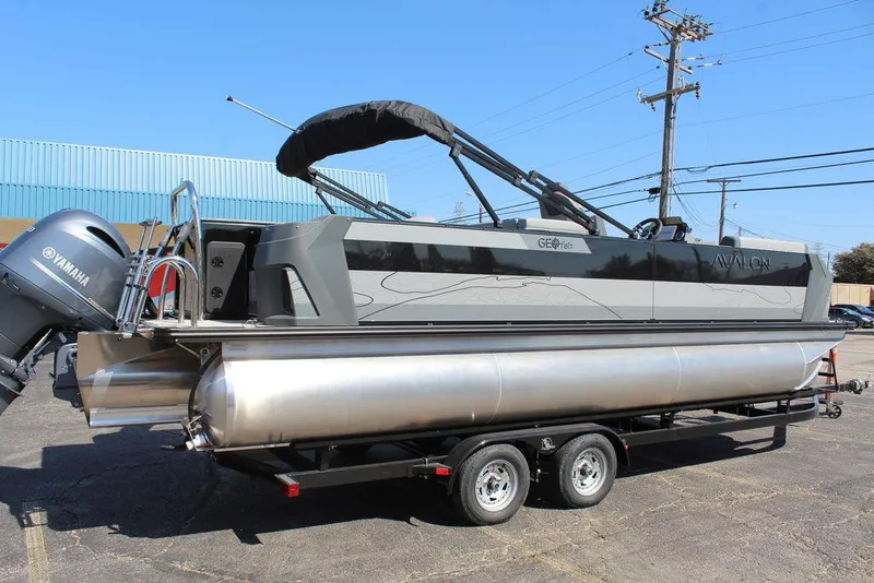 Slide: The Image of 2025 Avalon GEO FISH REAR FISH pontoon boat on trailer, featuring Yamaha engine. - 2
