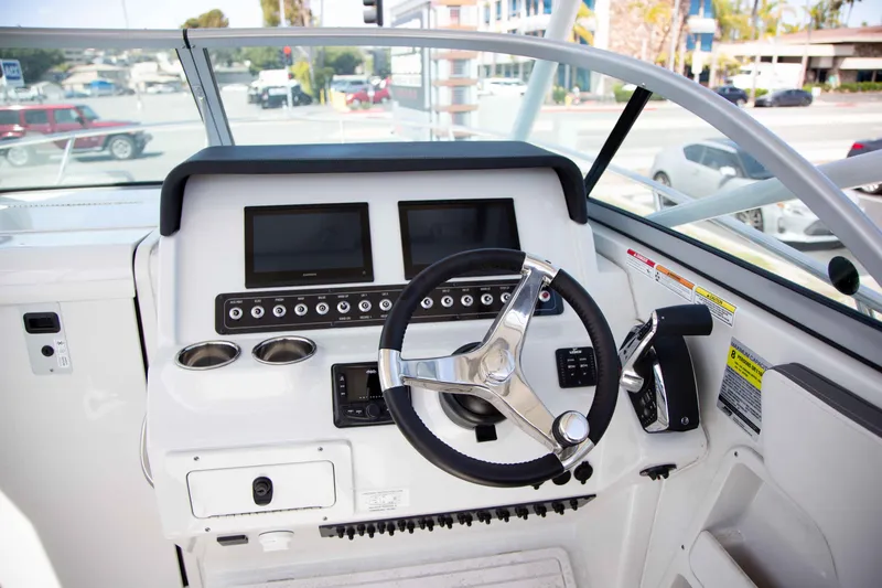 Slide: The Image of 2024 Finseeker 245 WA boat dashboard with dual screens and steering wheel. - 10