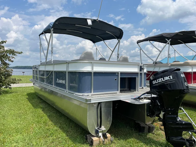 Slide: The Image of 2024 Landau A'Lure 212 Fishing boat with Suzuki motor, parked on grass under a blue sky. - 4