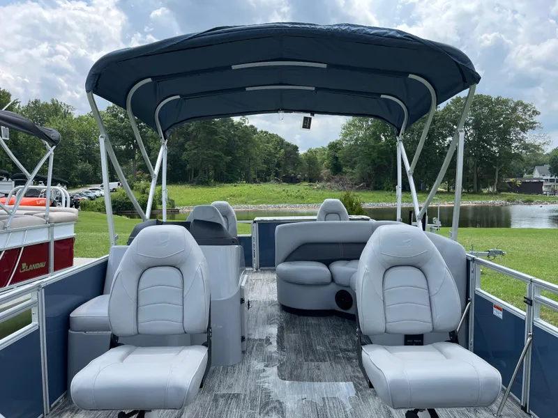 Slide: The Image of 2024 Landau A'Lure 212 Fishing boat with spacious seating and canopy, near a scenic lake. - 8