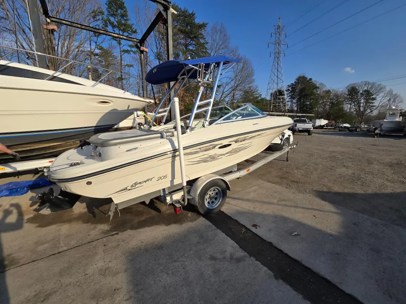The Image of 2008 Sea Ray 205 Sport boat on trailer, parked outdoors under blue sky. - 0