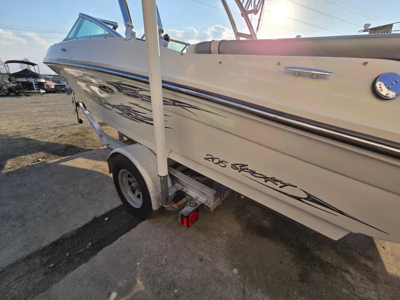 Slide: The Image of 2008 Sea Ray 205 Sport boat on trailer, side view with graphics, sunny day. - 12