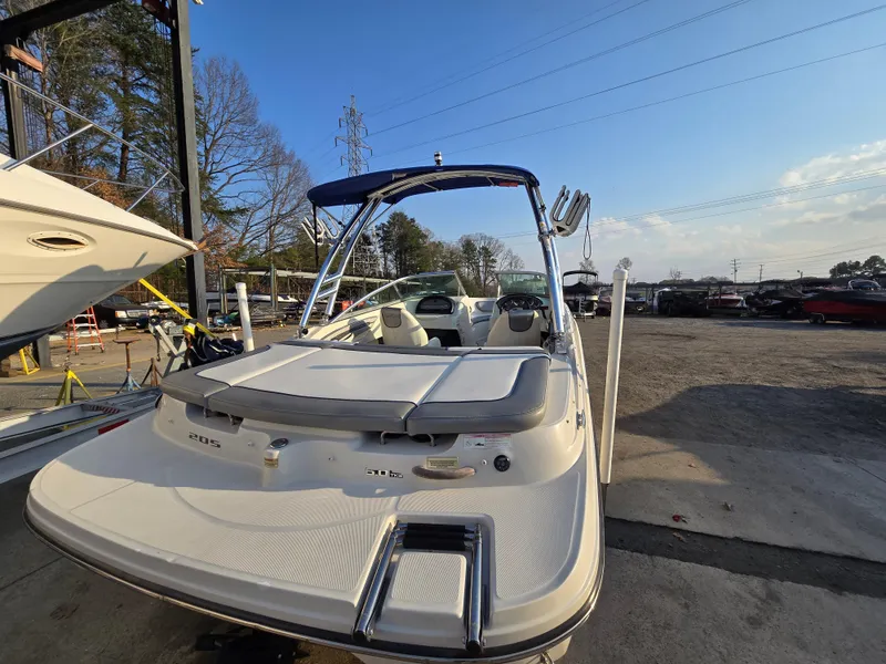 Slide: The Image of 2008 Sea Ray 205 Sport boat with blue canopy, parked outdoors on a sunny day. - 16