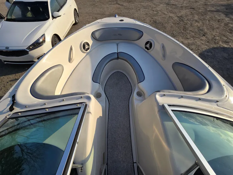 Slide: The Image of 2008 Sea Ray 205 Sport boat interior with seating, parked beside a white car. - 17