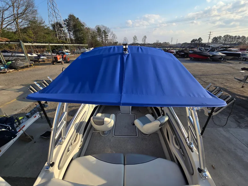 Slide: The Image of 2008 Sea Ray 205 Sport boat with blue canopy, docked in a marina. - 18