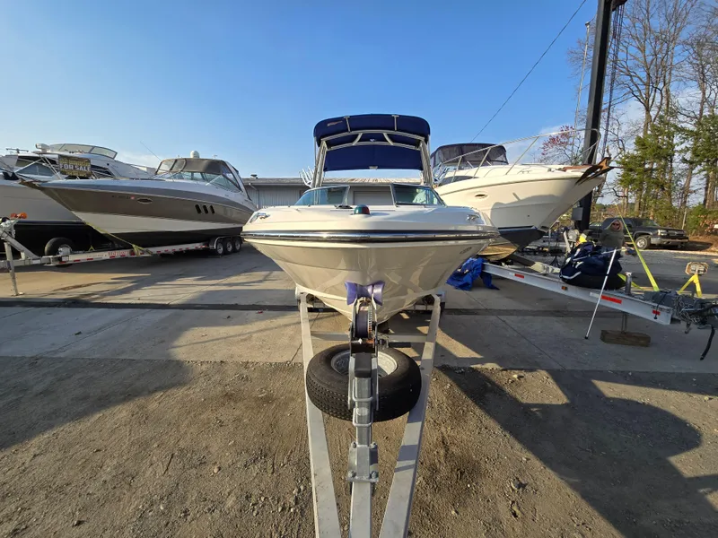 Slide: The Image of 2008 Sea Ray 205 Sport boat on trailer, parked in marina with other boats. - 2