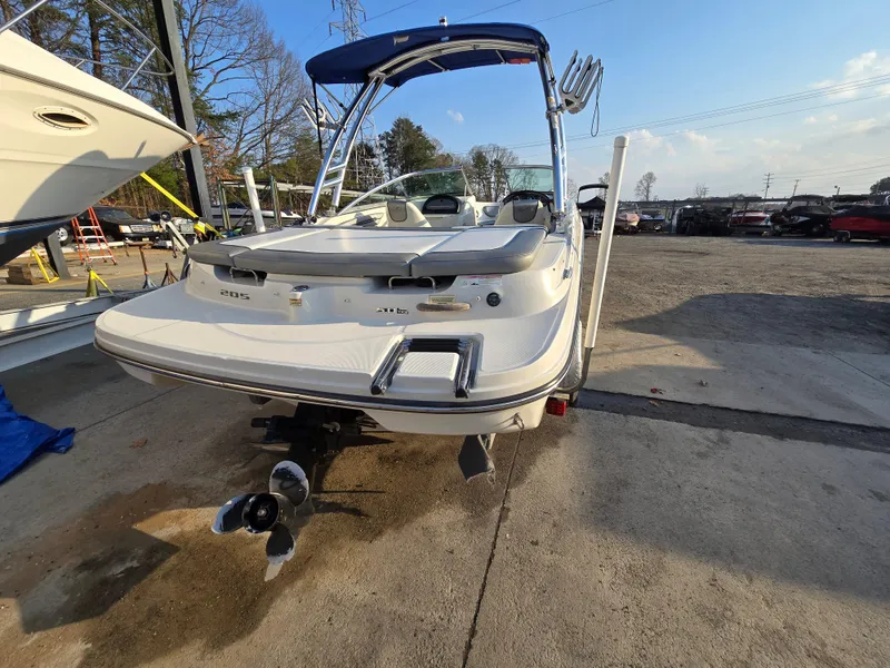 Slide: The Image of 2008 Sea Ray 205 Sport boat with blue canopy, parked on concrete. - 4