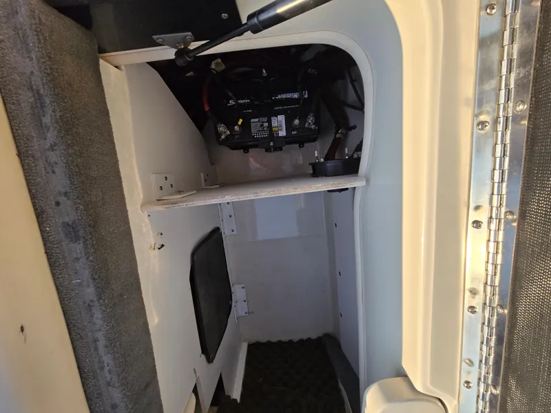 Slide: The Image of 2008 Sea Ray 205 Sport interior storage compartment with visible battery and wiring. - 42