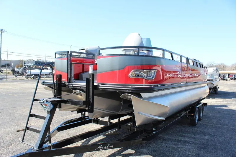 Slide: The Image of 2025 Avalon Venture 85 Center Console Fish boat, red and silver, on a trailer in a parking lot. - 6