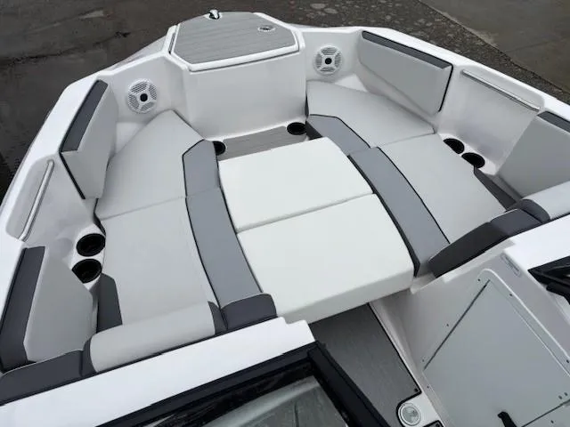 Slide: The Image of 2023 Yamaha Boats AR220 interior with gray and white seating, cup holders, and speakers. - 10