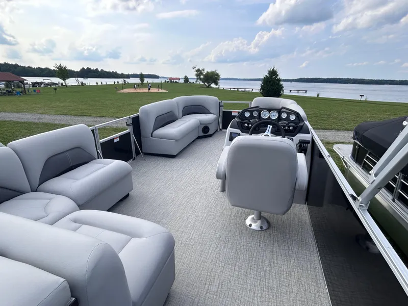 Slide: The Image of 2024 Landau Island Breeze 232 Cruise pontoon boat with spacious seating and scenic lake view. - 4