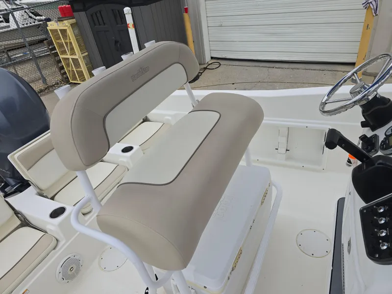 Slide: The Image of 2017 NauticStar 231 Coastal boat interior with beige seating and steering wheel. - 12