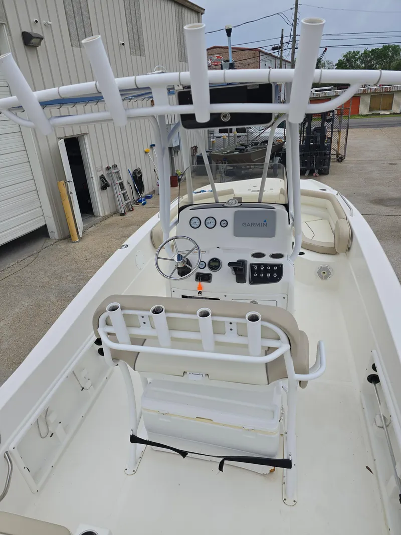 Slide: The Image of 2017 NauticStar 231 Coastal boat with center console and rod holders, docked outdoors. - 13